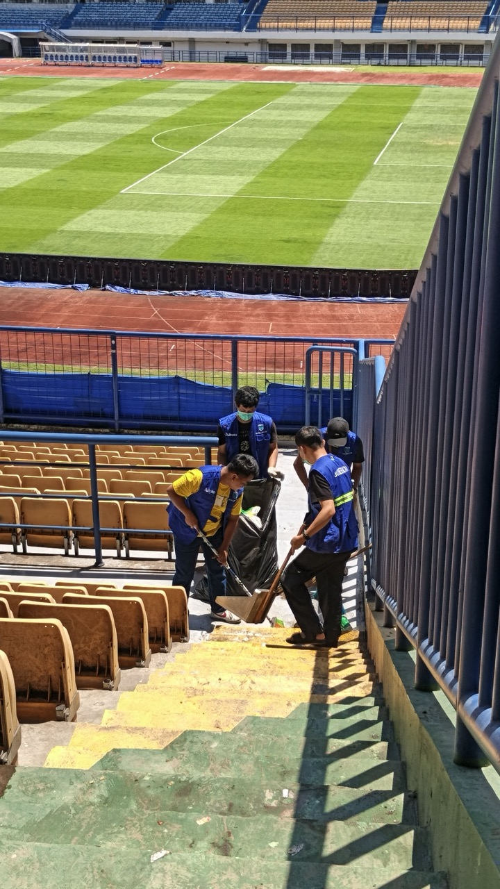 Tim membersihkan area tribun